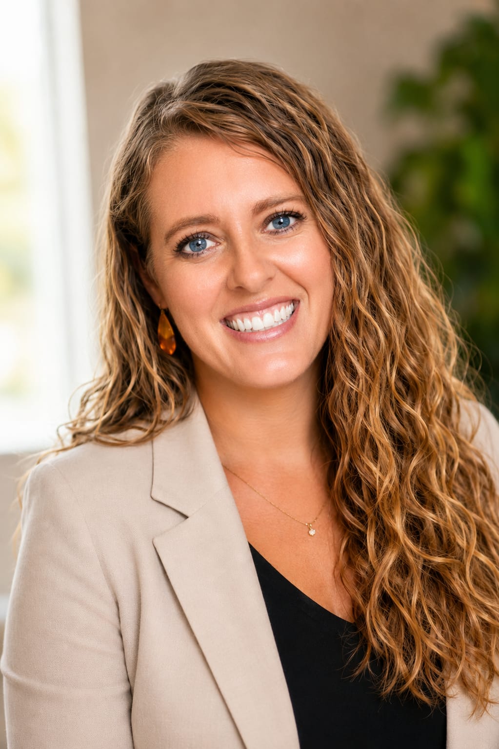 Holly Greer, Camp Director, smiling in a beige blazer