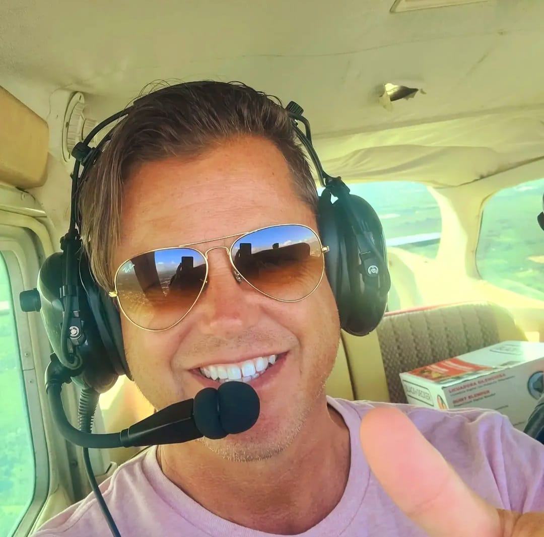 Jason Ryan, Co-Founder and Counselor, smiling in a small plane cockpit