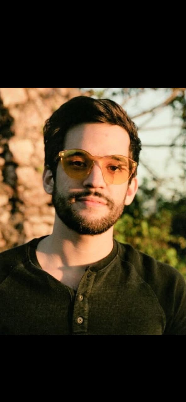 Sergio Díaz, Counselor, outdoors in tinted glasses and a dark henley